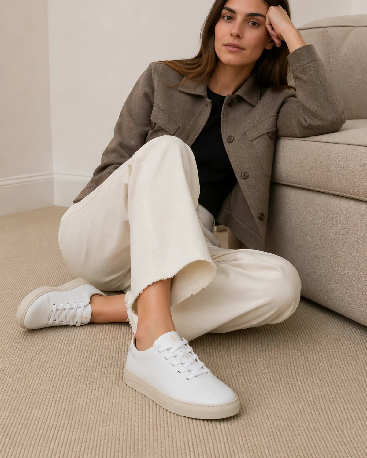 Mujer sentada en el suelo con pantalón crudo y sobrecamisa de lana llevando las Bauhaus pure white