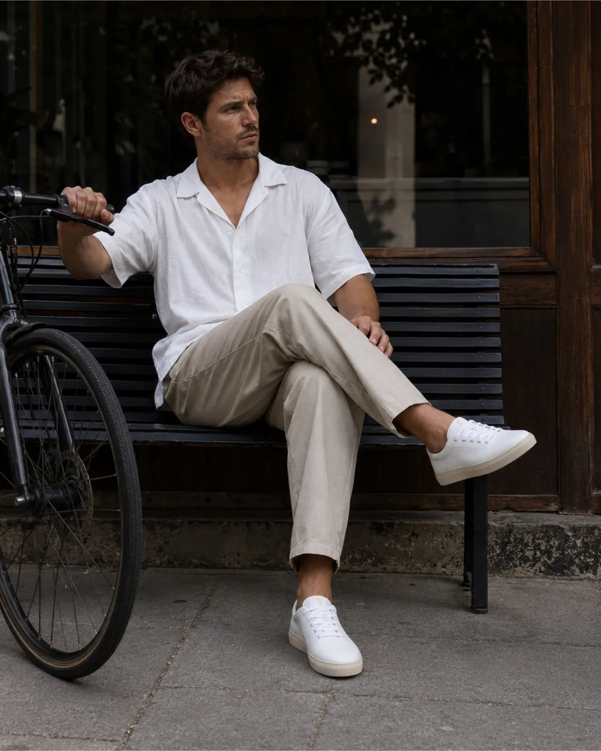 Hombre sentado en un banco con camisa de lino y pantalón crudo llevando las Bauhaus pure white