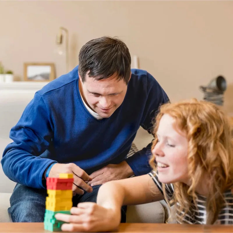 Dos personas jugando con bloques de colores en casa