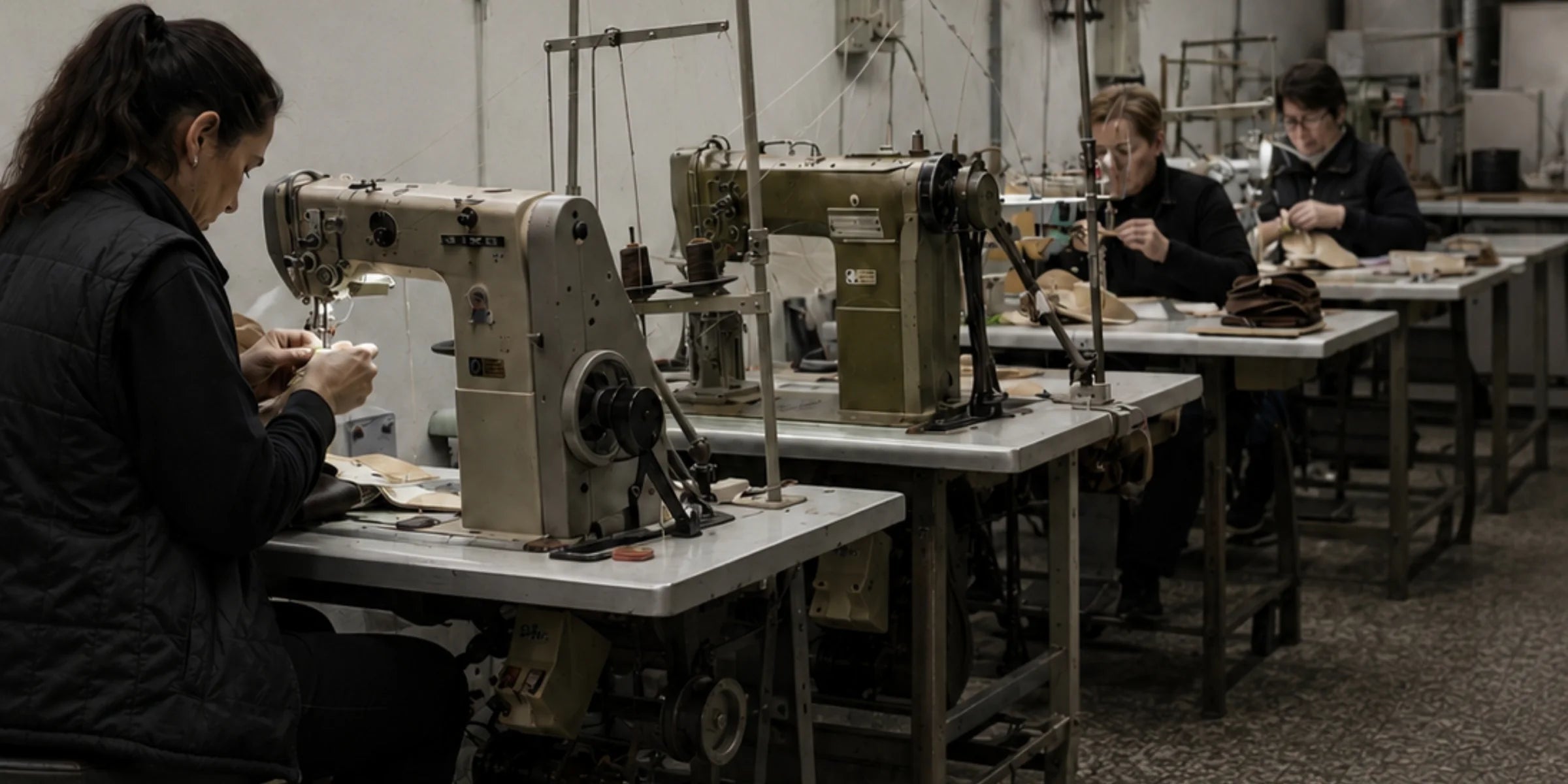 Sala de aparado del taller, con máquinas de coser y tres personas trabajando