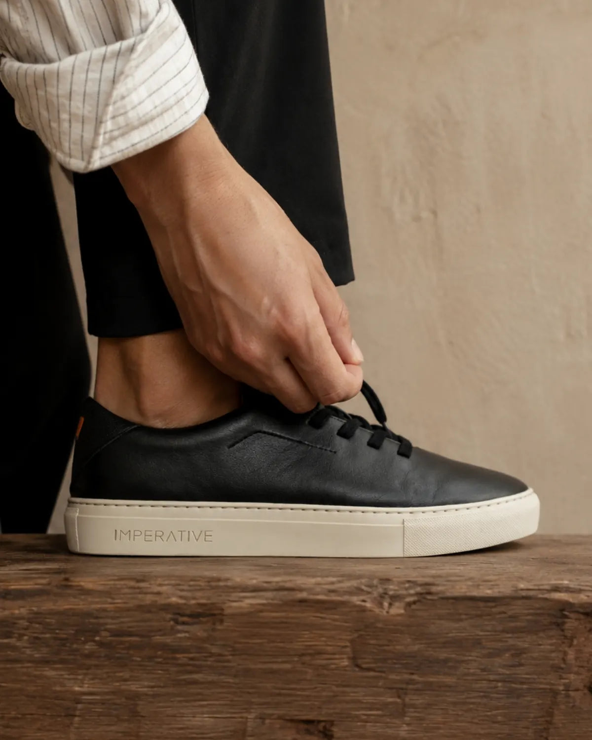Bauhaus night black atándose los cordones sobre un banco de madera